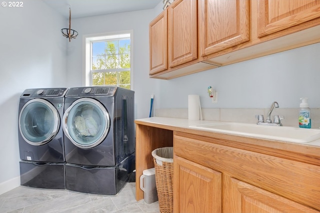 washroom with independent washer and dryer, sink, cabinets, and light tile floors