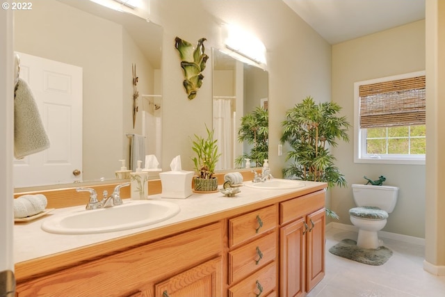 bathroom with double sink vanity, toilet, and tile floors