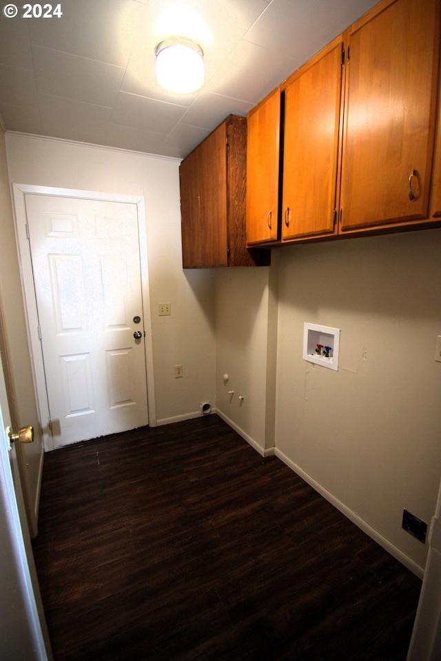 washroom featuring dark hardwood / wood-style floors, cabinets, and hookup for a washing machine