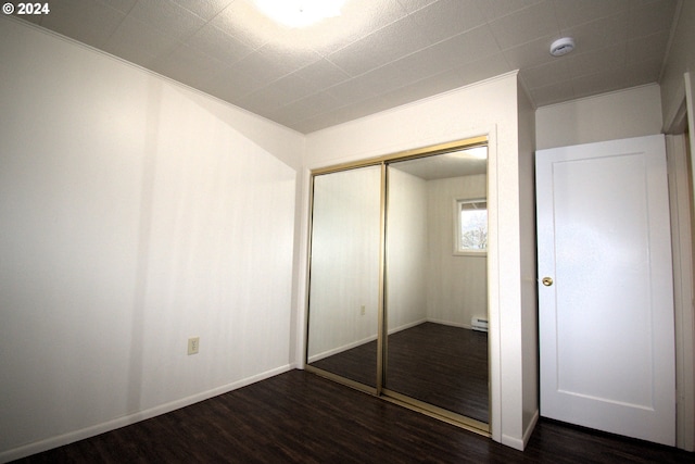 unfurnished bedroom with dark wood-type flooring and a closet