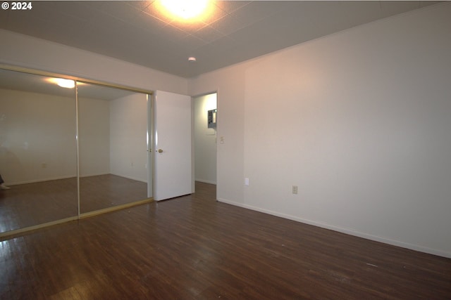 unfurnished bedroom with a closet and dark hardwood / wood-style flooring