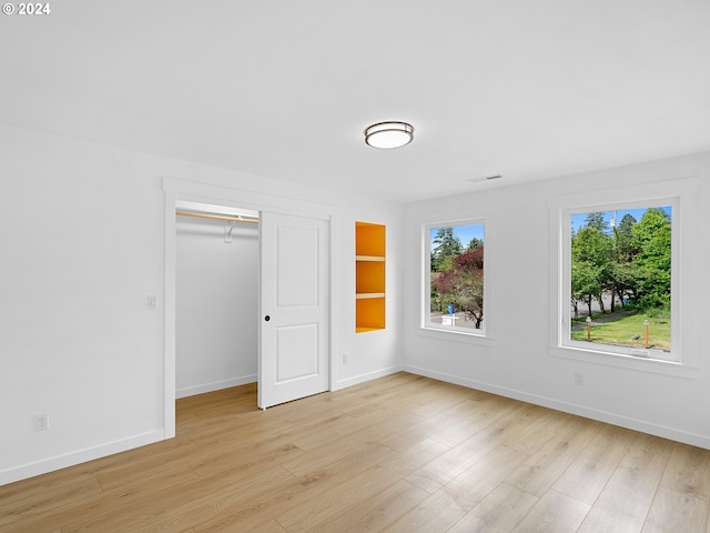 unfurnished bedroom featuring a closet and light hardwood / wood-style flooring