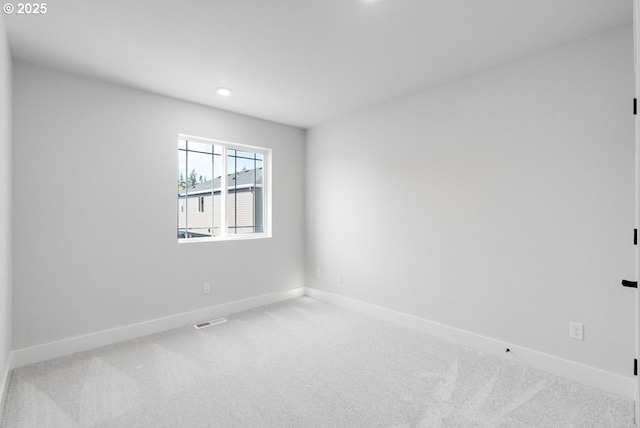 unfurnished room with baseboards, visible vents, and carpet