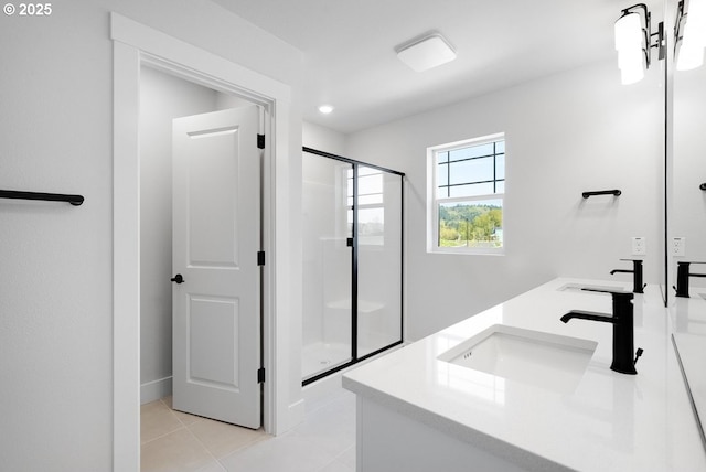 bathroom with double vanity, tile patterned floors, a stall shower, and a sink