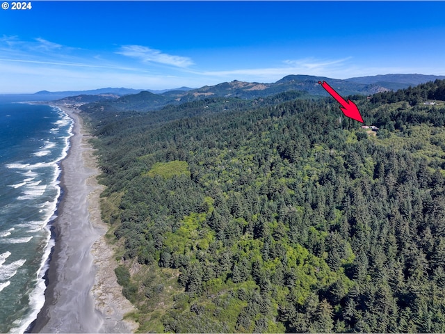 aerial view with a wooded view and a water and mountain view