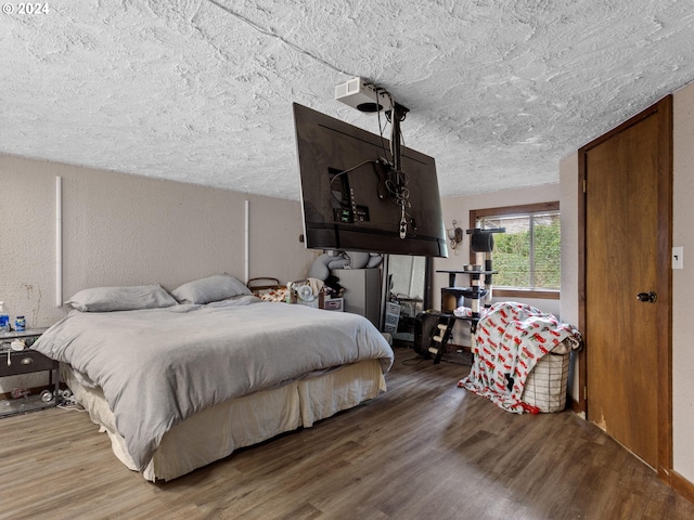 bedroom featuring wood-type flooring and a textured ceiling