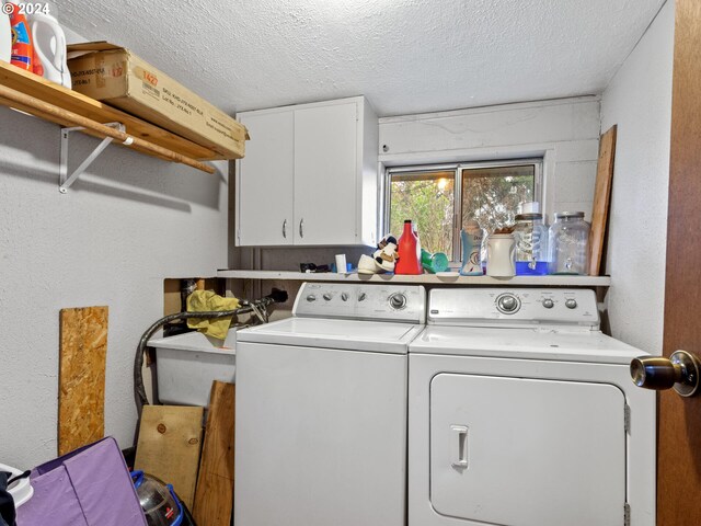 laundry area featuring cabinets, washer and dryer, and a textured ceiling