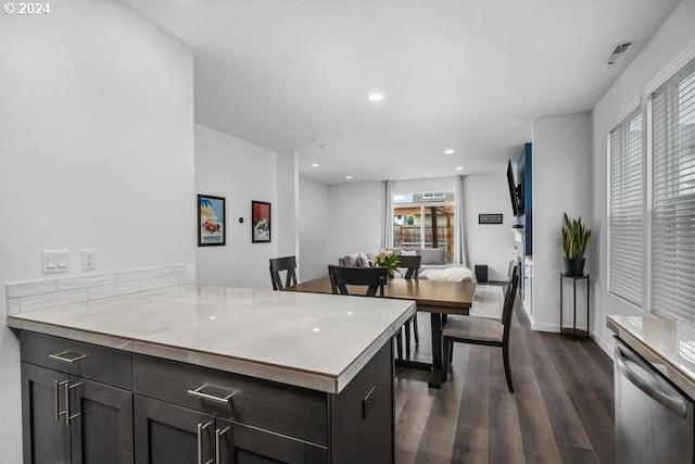 kitchen with dishwasher, dark brown cabinets, kitchen peninsula, and dark wood-type flooring