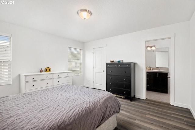 bedroom with dark wood-type flooring, connected bathroom, and multiple windows