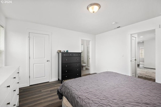 bedroom with ensuite bathroom and dark wood-type flooring