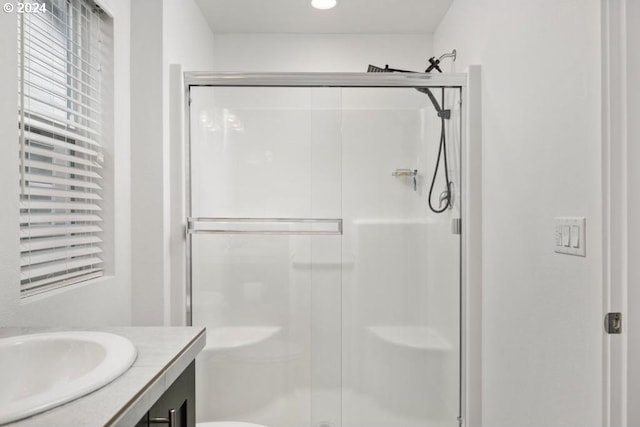 bathroom featuring vanity, a shower with shower door, and toilet