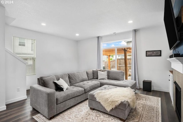 living room with a textured ceiling and dark hardwood / wood-style flooring