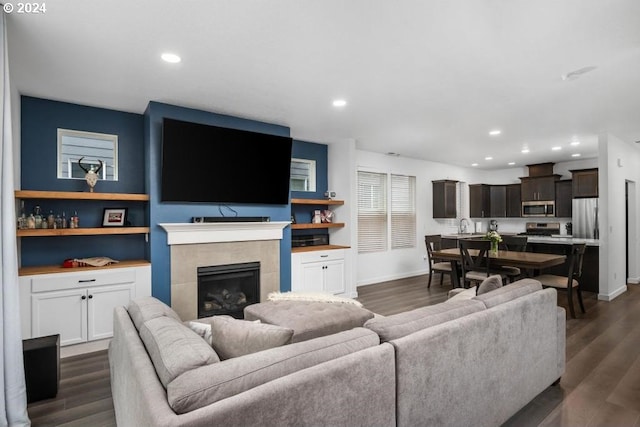 living room with sink, dark hardwood / wood-style flooring, and a fireplace