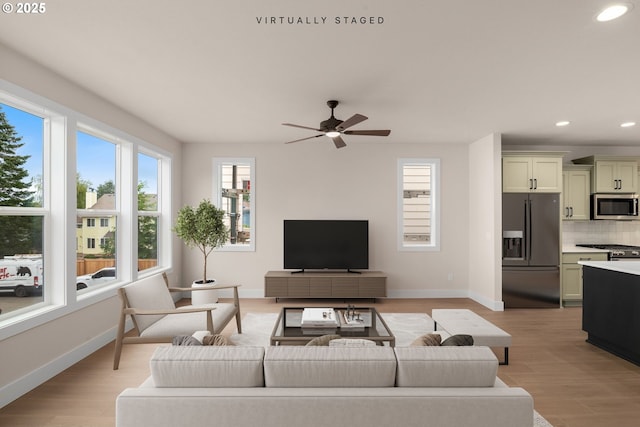 living area with light wood-style floors, recessed lighting, and baseboards