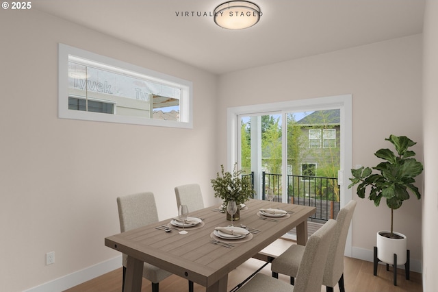 dining space with baseboards and wood finished floors