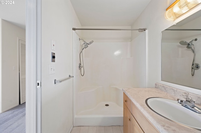 bathroom with tile patterned floors, vanity, and walk in shower