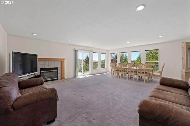 living room featuring a tile fireplace and light colored carpet