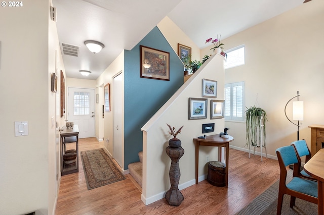 hallway featuring hardwood / wood-style flooring and vaulted ceiling