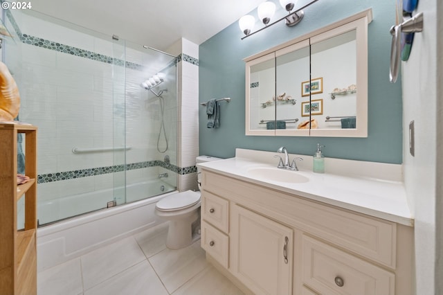 full bathroom with tile patterned floors, vanity, toilet, and bath / shower combo with glass door