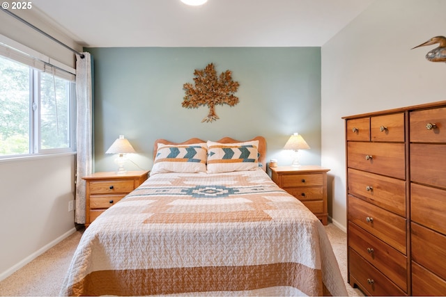 bedroom with baseboards and light colored carpet