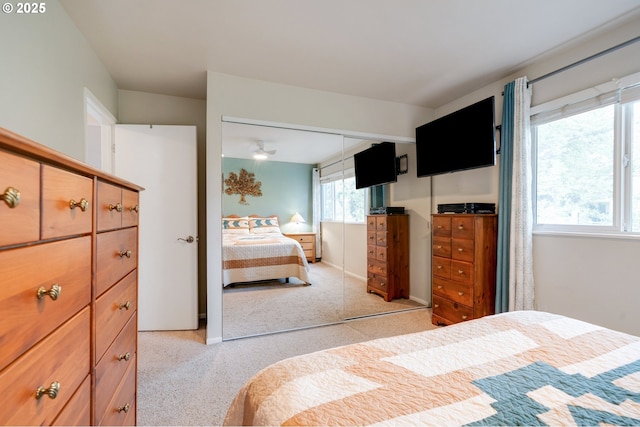 bedroom featuring light colored carpet and a closet
