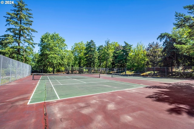 view of tennis court featuring fence and community basketball court