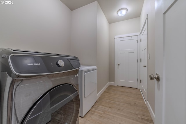 laundry area featuring washer and dryer and light wood-type flooring