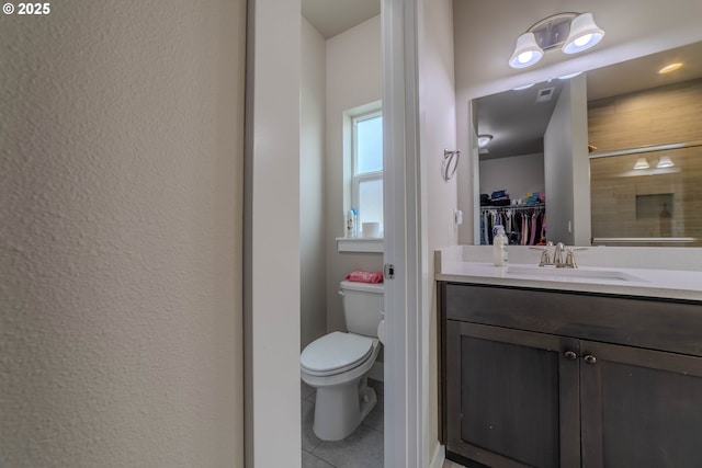 bathroom featuring vanity, tile patterned flooring, a shower with shower door, and toilet