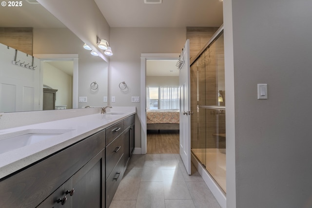 bathroom featuring tile patterned flooring, a shower with door, and vanity