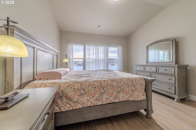 bedroom with light wood-type flooring and lofted ceiling