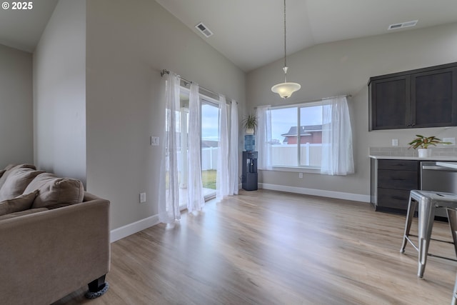 dining space featuring light hardwood / wood-style flooring and lofted ceiling