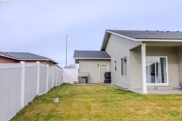 back of house featuring a lawn and a patio area