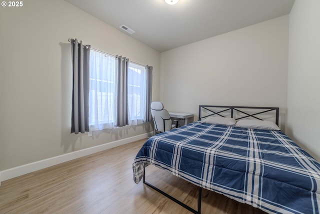 bedroom featuring hardwood / wood-style floors and vaulted ceiling