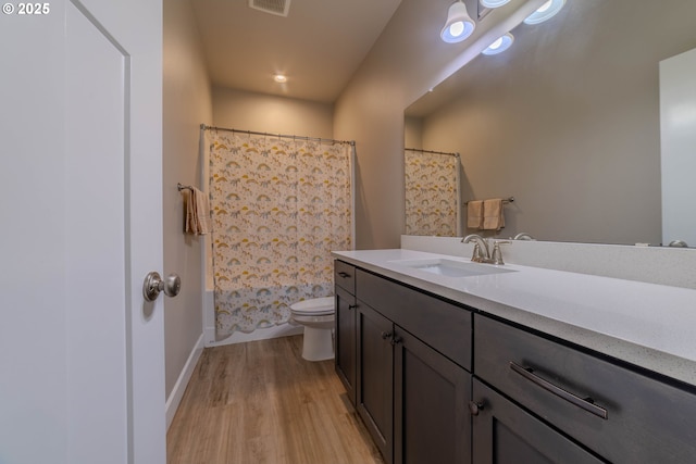 full bathroom with shower / bath combo with shower curtain, toilet, vanity, and hardwood / wood-style flooring