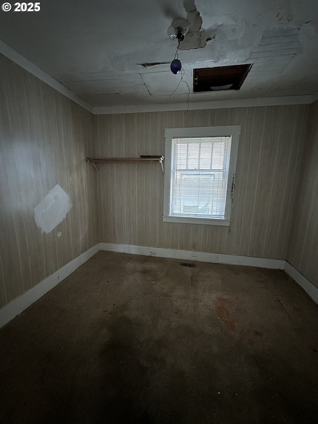 unfurnished room featuring wood walls