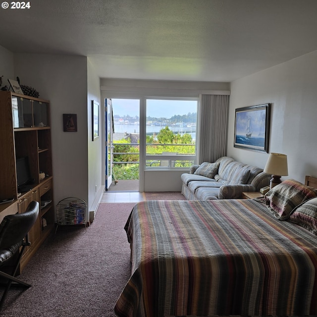 bedroom featuring a textured ceiling, access to exterior, a mountain view, and light colored carpet