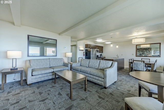 living room with sink, beamed ceiling, and carpet