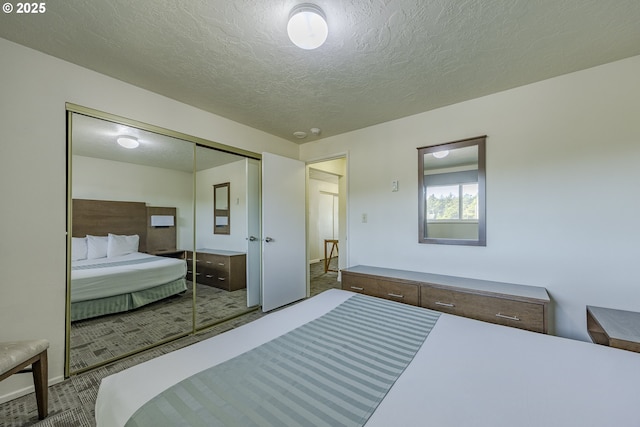 bedroom featuring carpet floors, a textured ceiling, and a closet