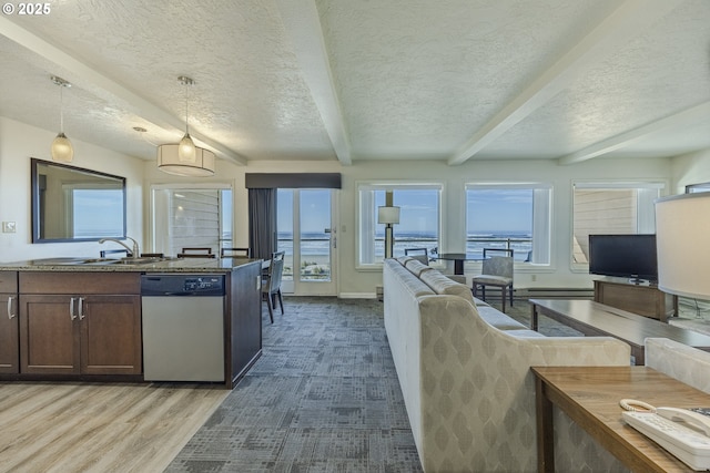 kitchen with sink, dishwasher, decorative light fixtures, beamed ceiling, and light wood-type flooring