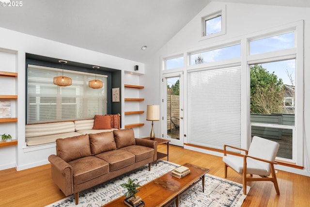 living room featuring vaulted ceiling and light hardwood / wood-style flooring