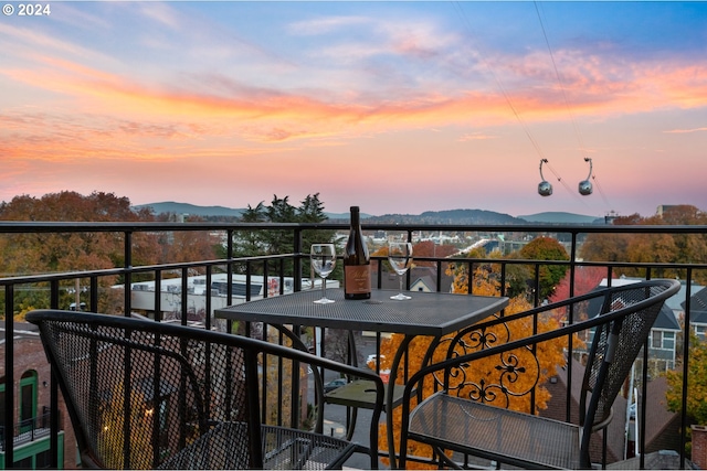 balcony at dusk featuring a mountain view