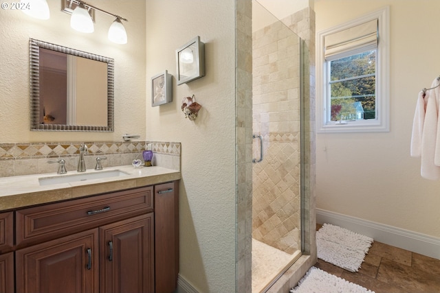 bathroom featuring a shower with shower door and vanity