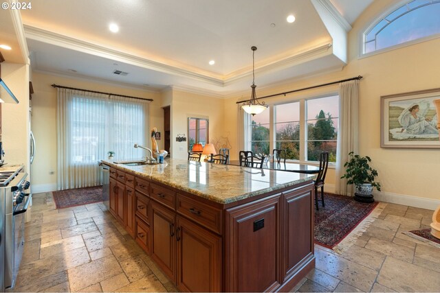 kitchen featuring sink, an island with sink, built in appliances, and crown molding