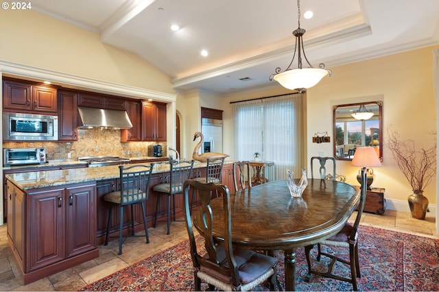 dining room featuring arched walkways, a toaster, crown molding, stone tile floors, and lofted ceiling