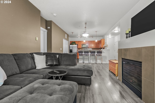 living room with light hardwood / wood-style floors and a tile fireplace