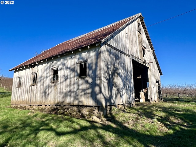 view of side of property featuring a lawn and an outdoor structure