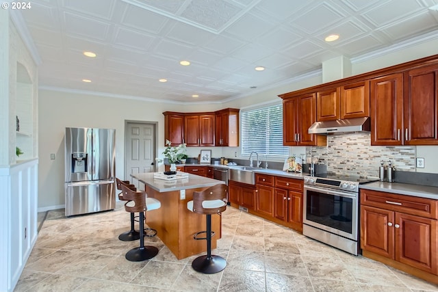 kitchen featuring a breakfast bar, a center island, stainless steel appliances, light countertops, and under cabinet range hood