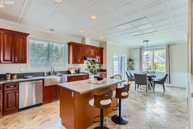 kitchen with a sink, a kitchen island, hanging light fixtures, stainless steel dishwasher, and an ornate ceiling