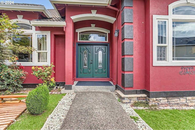 doorway to property featuring stucco siding