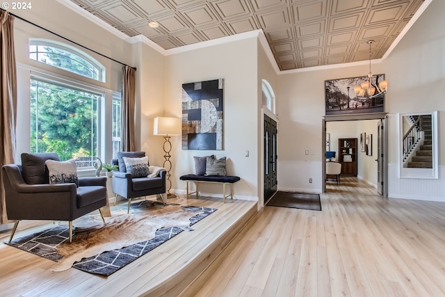 foyer entrance with stairs, wood-type flooring, an ornate ceiling, and crown molding